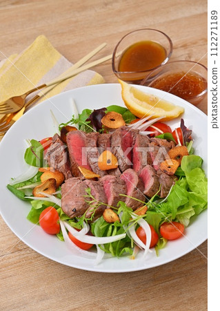 豐盛的牛排沙拉、蔬菜沙拉、牛大腿牛排和調味料。 112271189