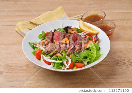 A hearty steak salad, vegetable salad, beef thigh steak, and dressing. A hearty steak salad, vegetable salad, beef thigh steak, and dressing. 112271190