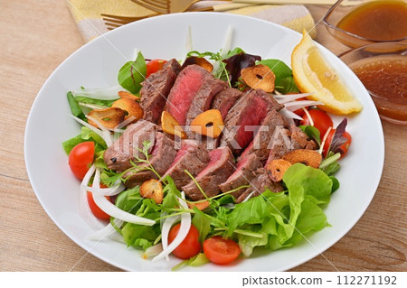 豐盛的牛排沙拉、蔬菜沙拉、牛大腿牛排和調味料。 112271192