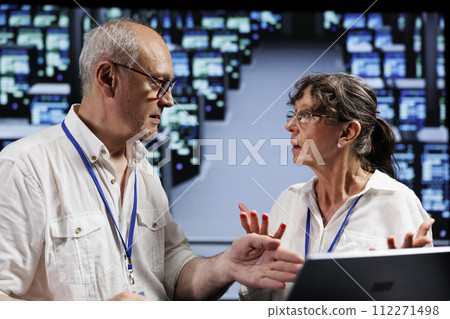Octogenarian employees working to maintain uptime in high tech workspace. Efficient workers brainstorming solutions to data center blade servers crashing, trying to fix components Octogenarian employees working to maintain uptime in high tech workspace. Efficient workers brainstorming solutions to data center blade servers crashing, trying to fix components 112271498