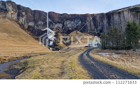 Foss a Sidu waterfall and farmhouse in Iceland, pouring from edge of hill and creating idyllic natural landscape. Gorgeous nordic cascade with water stream falling from slopes. 112271633