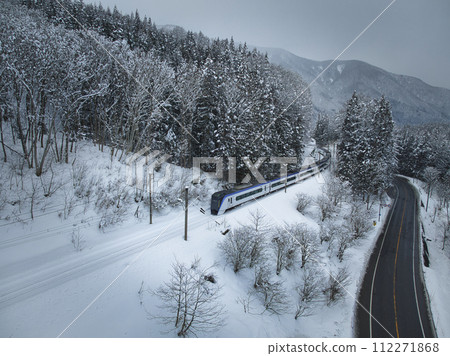 Limited Express Azusa running through the snowy Sanozaka Pass in Hakuba Village, Nagano Prefecture (aerial shot by drone) Limited Express Azusa running through the snowy Sanozaka Pass in Hakuba Village, Nagano Prefecture (aerial shot by drone) 112271868