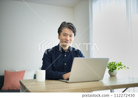 Middle-aged man doing telework in the living room 112272430