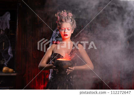 Halloween Witch with cauldron. Beautiful young Halloween Witch with cauldron. Beautiful young 112272647