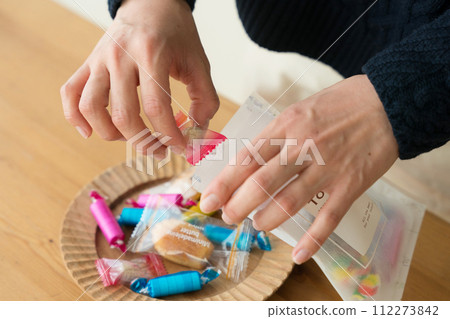 女人的手把糖果放進袋子裡 112273842