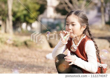 Girls playing with soap bubbles Girls playing with soap bubbles 112274047