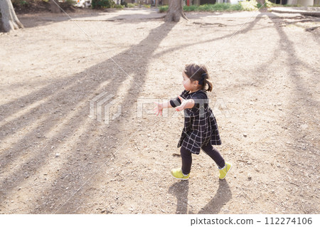 little girl running in the park 112274106