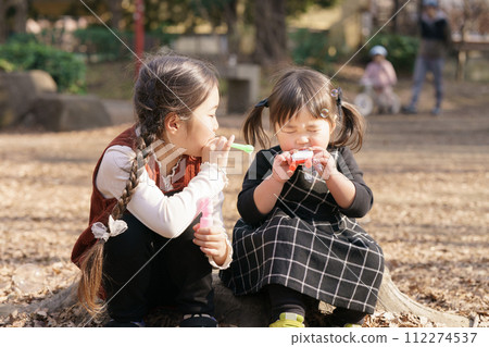 Girls playing with soap bubbles 112274537
