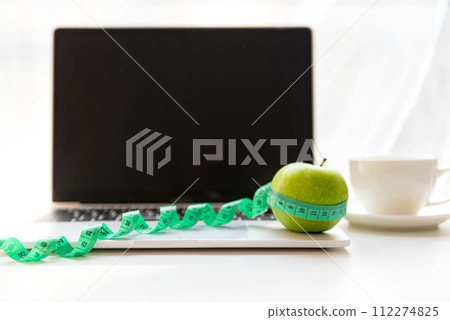 Close up green apple and tape measure.  Healthy snack for diet planning for working in office. 112274825