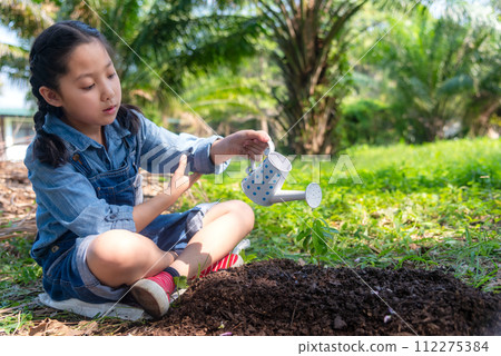 Asia girl  gardener watering can water of young green plants 112275384