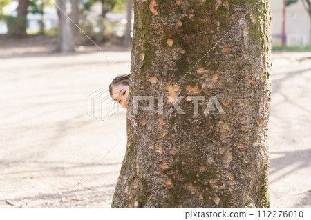 girl hiding in a big tree girl hiding in a big tree 112276010