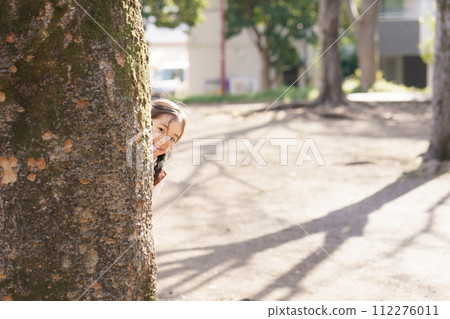 girl hiding in a big tree girl hiding in a big tree 112276011