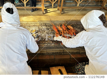 在日本三重縣的海女小屋裡，海女潛水員在木炭上燒烤新鮮的龍蝦和貝類 112276149