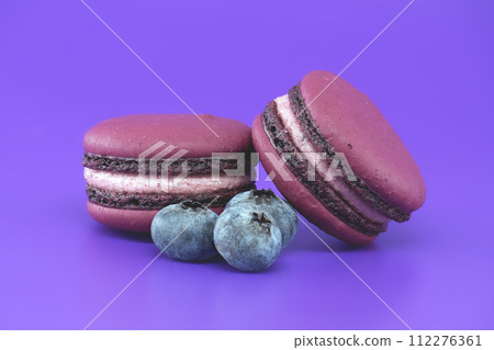 Macarons and blueberries over purple background 112276361