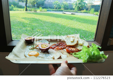 toast with bacon, fried egg and lettuce or sunny side up egg with bacon and  mushroom 112276523