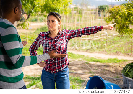 Gardeners havilng conflict together after harvesting of vegetables Gardeners havilng conflict together after harvesting of vegetables 112277487