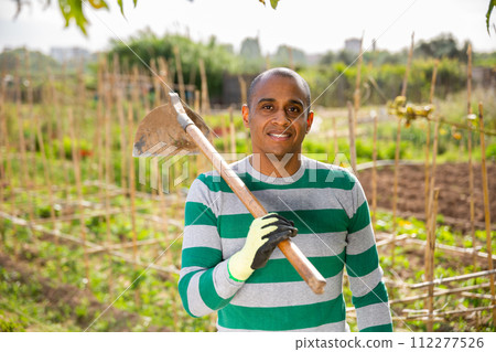 Working Indian with hoePortrait of working Indian with hoe on farm field 112277526