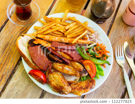 Various types of meat with vegetables and french fries. Turkish cuisine Various types of meat with vegetables and french fries. Turkish cuisine 112277825