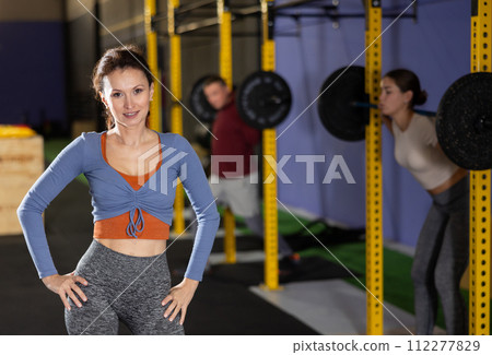Smiling woman in sportswear posing during training in gym 112277829
