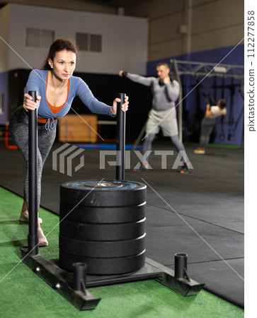Adult woman training on crossfit sled 112277858