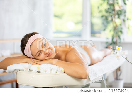 Young woman lying on massage table in office Young woman lying on massage table in office 112278034
