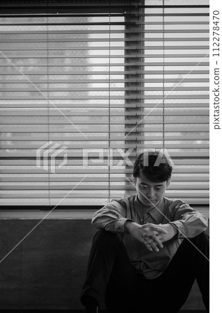 Young man depressed in a dark room Young man depressed in a dark room 112278470