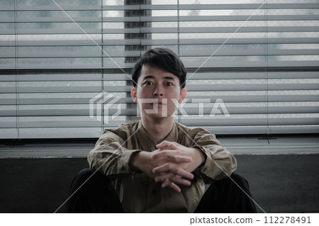 Young man depressed in a dark room 112278491