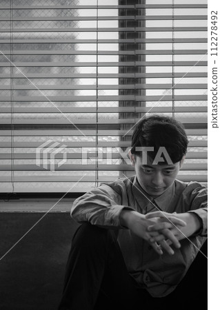 Young man depressed in a dark room 112278492