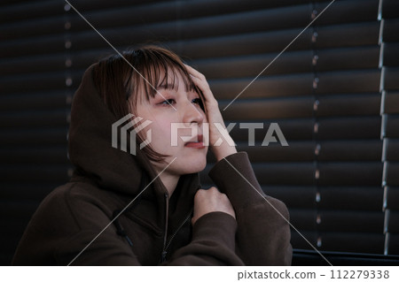 depressed woman in a dark room 112279338