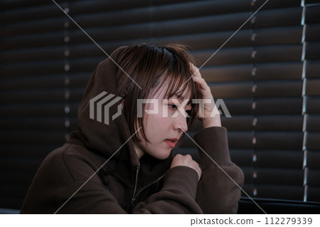 depressed woman in a dark room 112279339