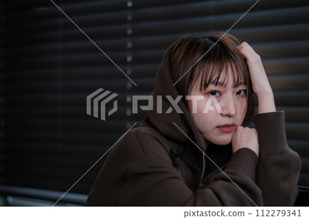 depressed woman in a dark room 112279341