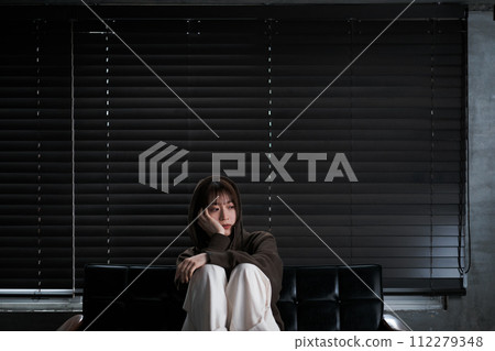 depressed woman in a dark room 112279348