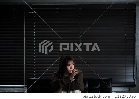 depressed woman in a dark room 112279350