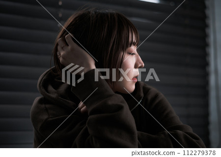depressed woman in a dark room 112279378