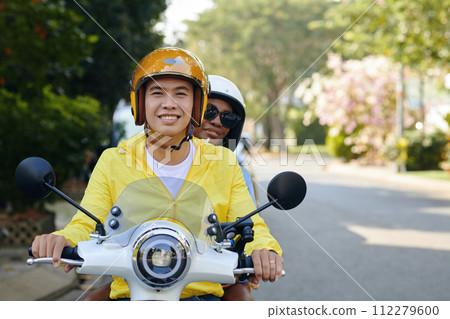 Portrait of smiling motorcycle taxi driver riding with passenger Portrait of smiling motorcycle taxi driver riding with passenger 112279600