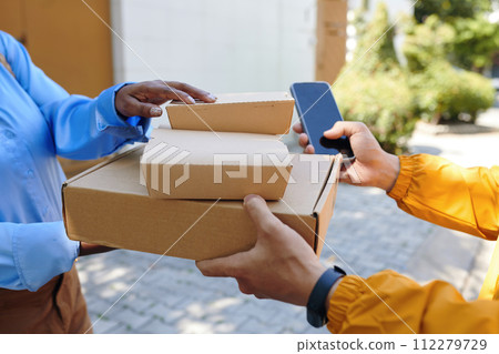 Hands of delivery man giving boxes with food to customer Hands of delivery man giving boxes with food to customer 112279729