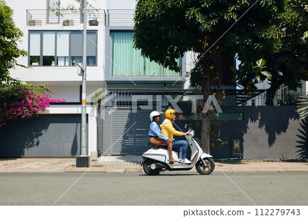 Woman using motorbike taxi service to get to office Woman using motorbike taxi service to get to office 112279743
