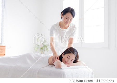 接受按摩的年輕女子和美容師 接受按摩的年輕女子和美容師 112280225