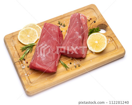 Fresh tuna Fish steak on a wooden cutting serving board isolated on a white background Fresh tuna Fish steak on a wooden cutting serving board isolated on a white background 112281240