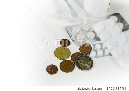 A pile of euro coins and medications pills in the blister pack. A pile of euro coins and medications pills in the blister pack. 112281564