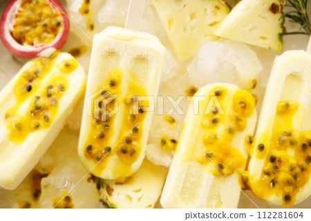 Pineapple popsicles with fresh passion fruit in ice tray. Pineapple popsicles with fresh passion fruit in ice tray. 112281604