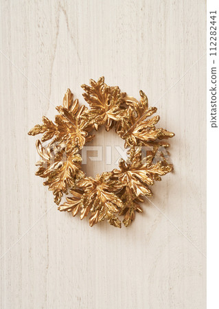 Golden Christmas wreath placed on a white antique board 112282441