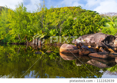 Still lake on a sunny summer day. Landscape of Anse Lazio, Praslin Still lake on a sunny summer day. Landscape of Anse Lazio, Praslin 112282639