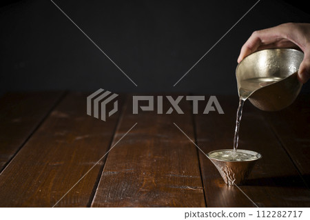 冷清酒倒入錫清酒杯中的影像，水平位置 3 112282717