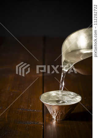 冷清酒倒入錫酒杯中的影像，垂直位置 5 112282722