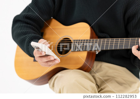 Man playing guitar, white background, smartphone Man playing guitar, white background, smartphone 112282953