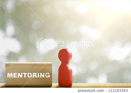 Wooden block with 'mentoring' text and a red wooden peg doll Wooden block with 'mentoring' text and a red wooden peg doll 112283363