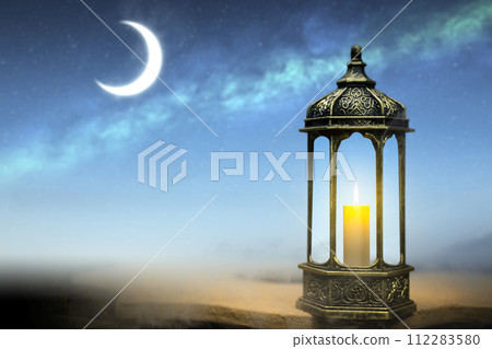 Ornamental Arabic lantern with burning candle glowing Ornamental Arabic lantern with burning candle glowing 112283580
