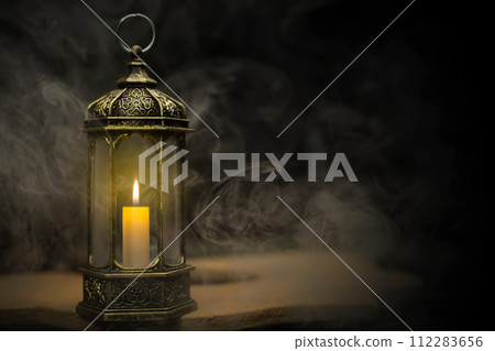 Ornamental Arabic lantern with burning candle glowing Ornamental Arabic lantern with burning candle glowing 112283656