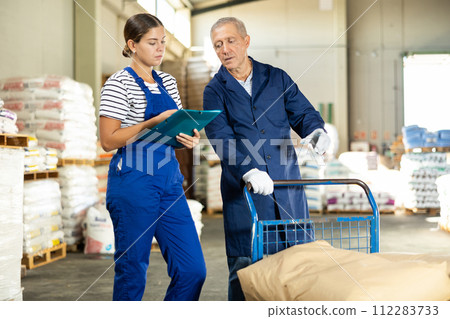 Young woman and elderly man checking documents in warehouse 112283733